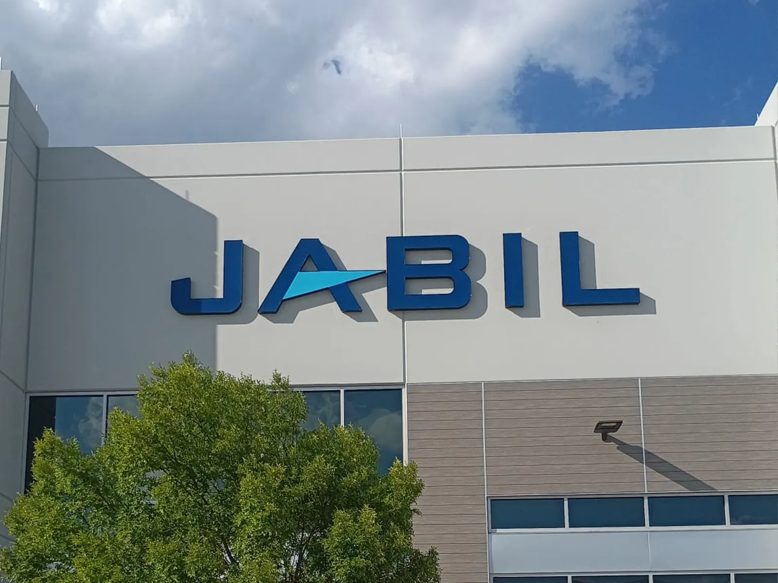 Jabil blue channel letters high on the facade of a manufacturing building